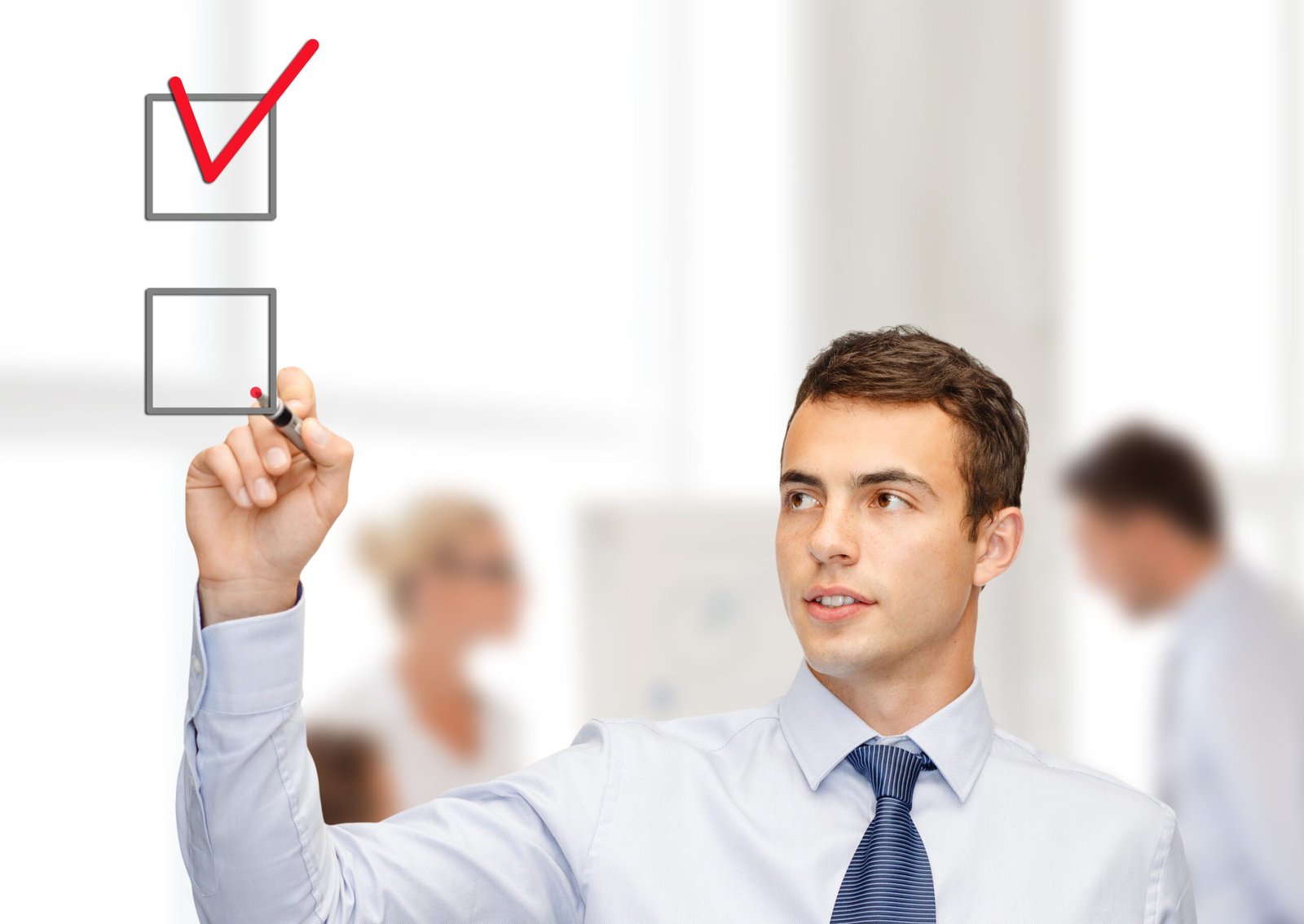 business and office concept - attractive buisnessman or teacher with marker drawning red checkmark into checkbox